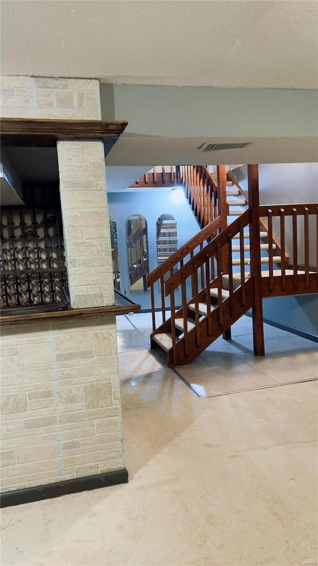 staircase with visible vents and a textured ceiling