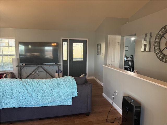 bedroom featuring lofted ceiling, baseboards, and wood finished floors