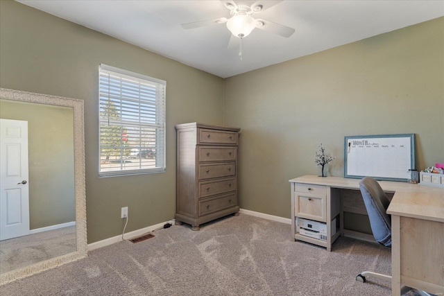 office area featuring a ceiling fan, light carpet, visible vents, and baseboards