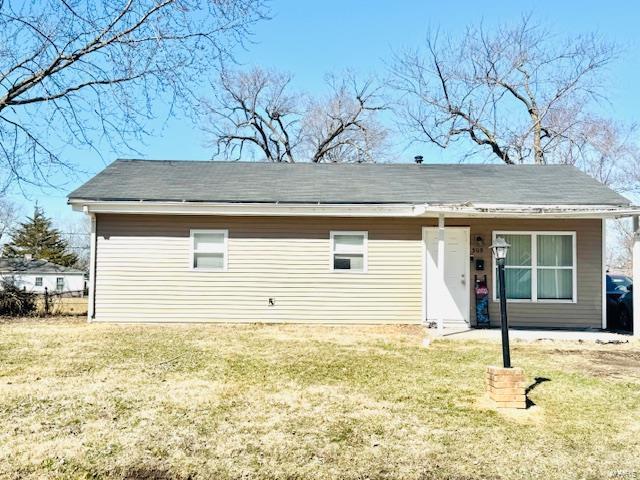 rear view of property featuring a yard