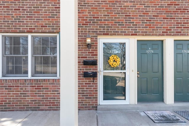 entrance to property featuring brick siding