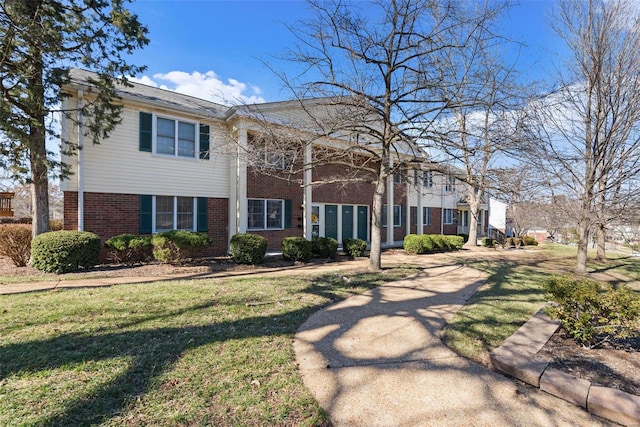 view of front of house featuring brick siding and a front lawn