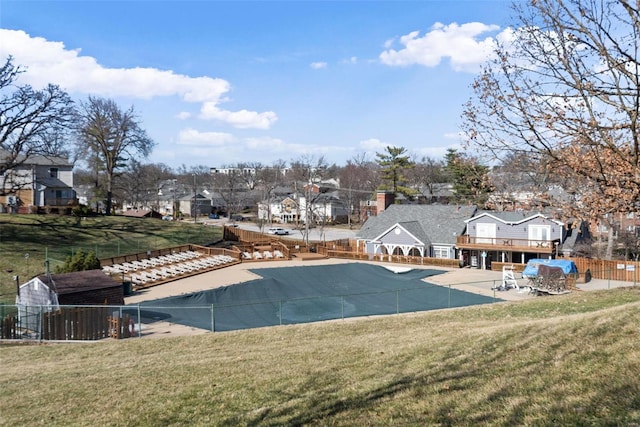 view of swimming pool featuring a yard, fence, and a residential view