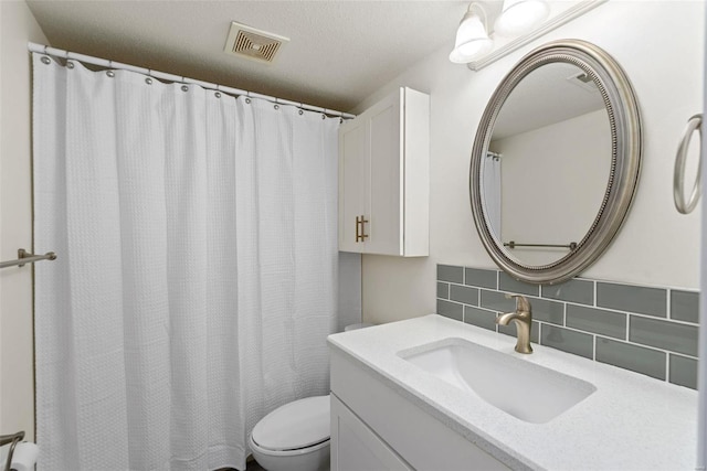 bathroom featuring visible vents, toilet, vanity, and decorative backsplash