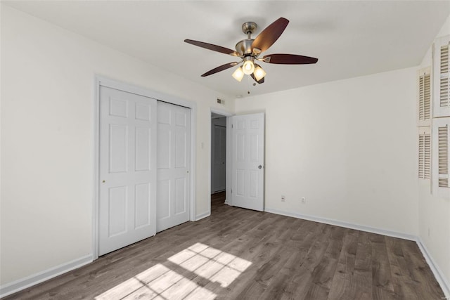 unfurnished bedroom with visible vents, a ceiling fan, wood finished floors, a closet, and baseboards