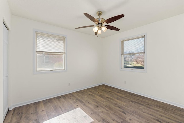 empty room featuring ceiling fan, baseboards, and wood finished floors