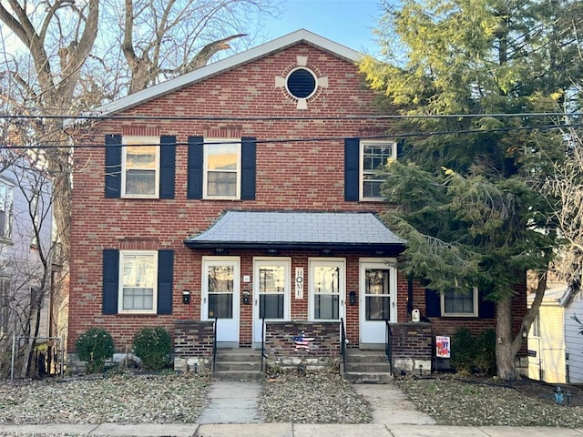 view of front of house featuring covered porch and brick siding