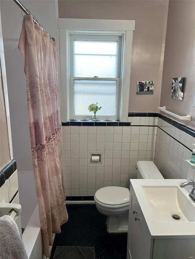 bathroom with a shower with shower curtain, tile walls, toilet, and vanity