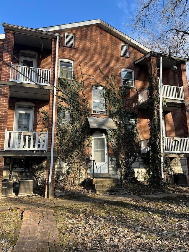 view of side of property with central AC and brick siding