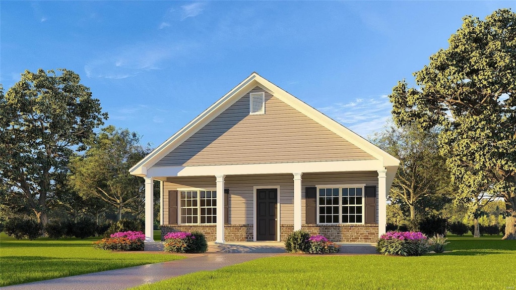 view of front of property with covered porch, a front lawn, and brick siding