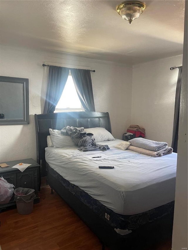 bedroom featuring a textured ceiling and wood finished floors