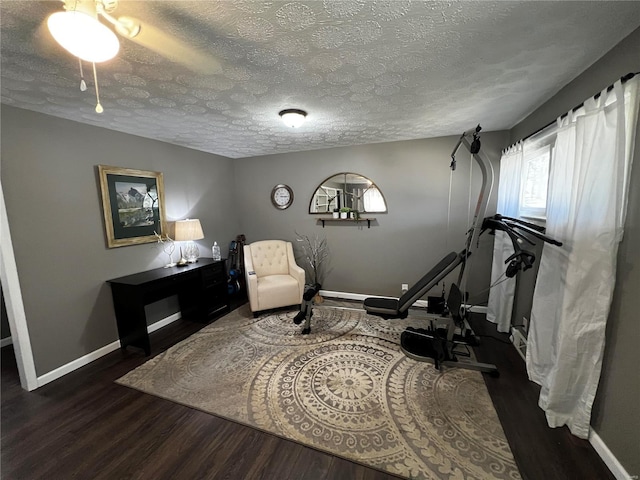 interior space with a textured ceiling, wood finished floors, and baseboards