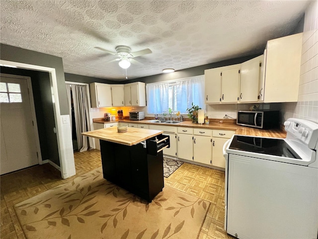 kitchen featuring white cabinetry, butcher block counters, white range with electric stovetop, and stainless steel microwave