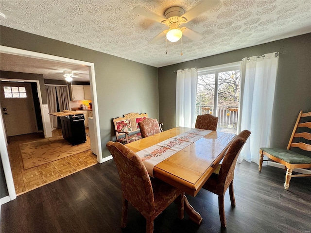 dining room featuring ceiling fan, a textured ceiling, wood finished floors, and baseboards