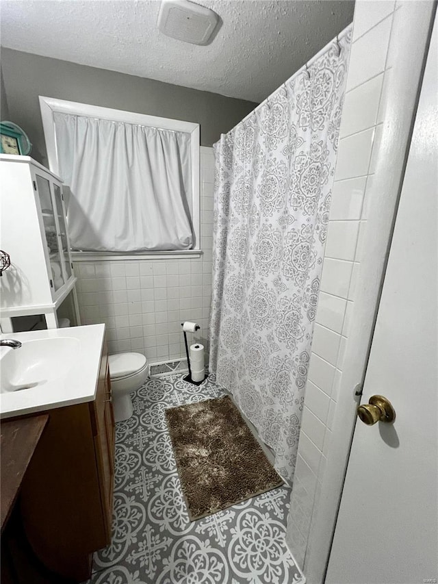 full bath with tile walls, toilet, a textured ceiling, and a shower with curtain