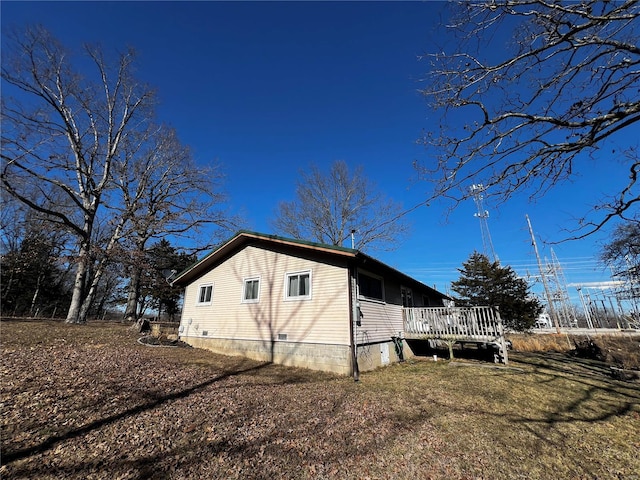 view of side of home with a deck and a yard