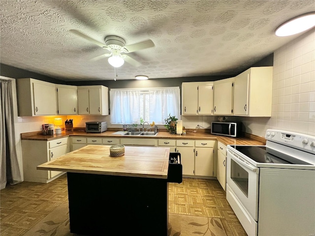 kitchen with white range with electric cooktop, a sink, wooden counters, light floors, and stainless steel microwave