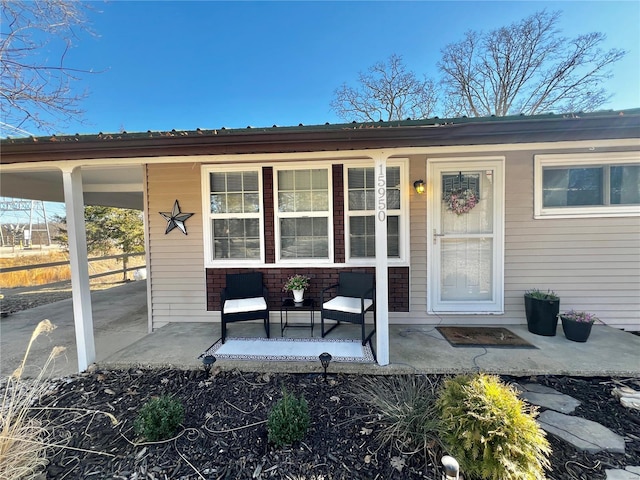 entrance to property featuring a carport and a porch