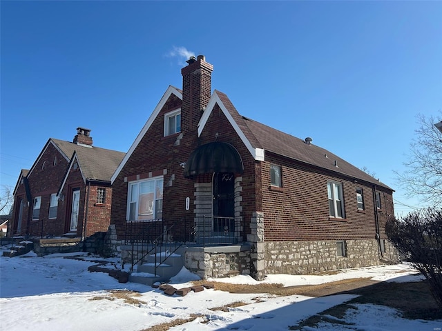 view of front of property featuring brick siding and a chimney