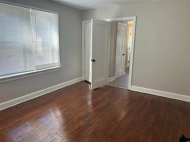 empty room with baseboards and wood finished floors