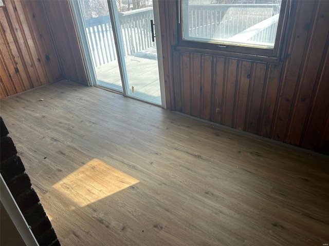 empty room featuring wood finished floors and wooden walls