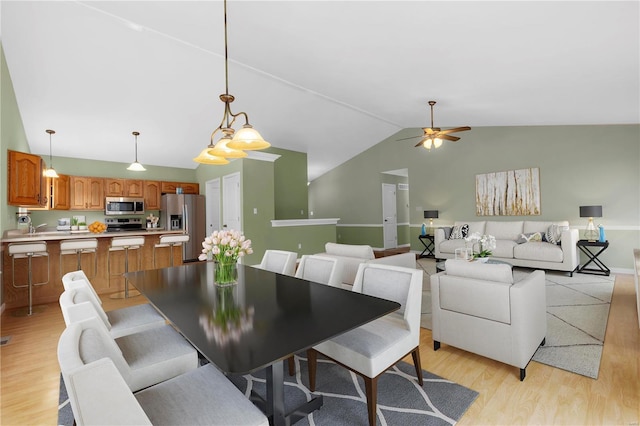 dining area with lofted ceiling, light wood-type flooring, and a ceiling fan