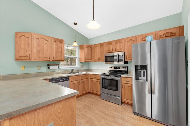 kitchen with lofted ceiling, stainless steel appliances, a sink, hanging light fixtures, and light countertops