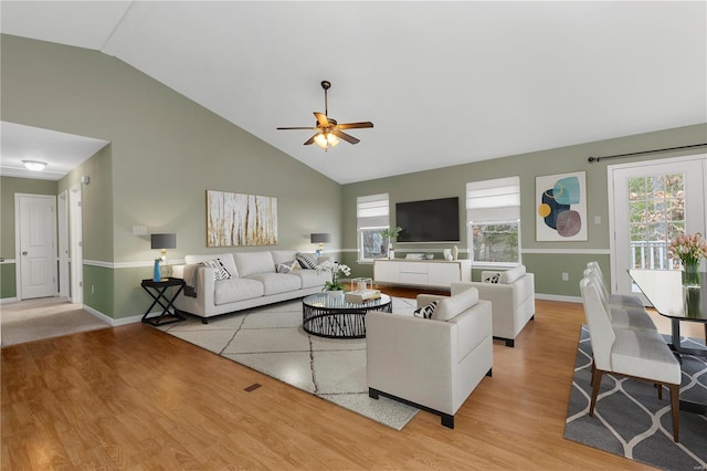 living room featuring ceiling fan, high vaulted ceiling, wood finished floors, and baseboards