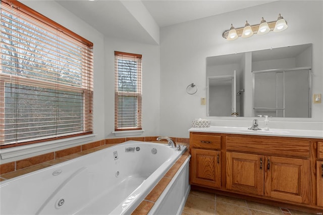 full bathroom featuring a stall shower, vanity, a tub with jets, and tile patterned floors