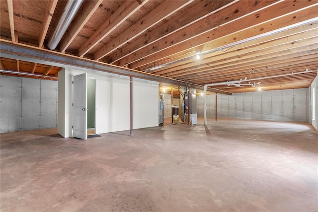 unfinished basement featuring heating unit and water heater