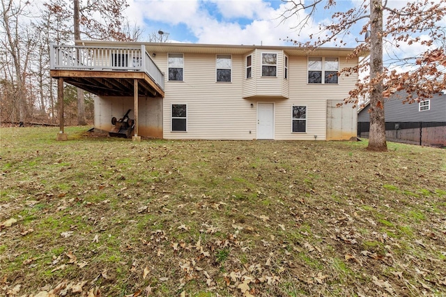 back of house featuring a lawn and a wooden deck