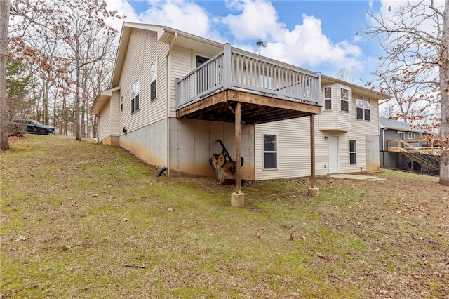 rear view of property featuring a deck and a yard