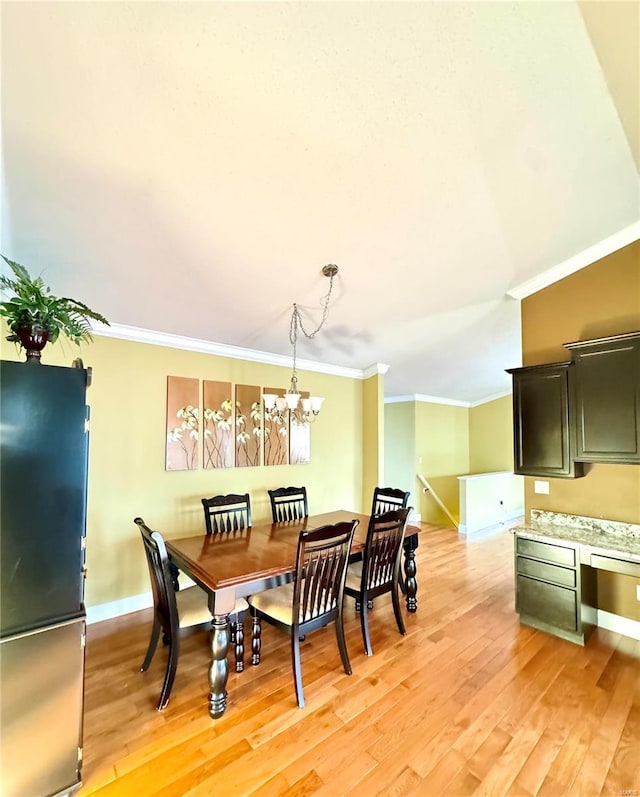 dining room with light wood-style flooring, baseboards, a chandelier, and ornamental molding