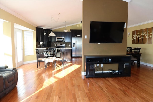 living area featuring light wood-type flooring, baseboards, ornamental molding, and vaulted ceiling