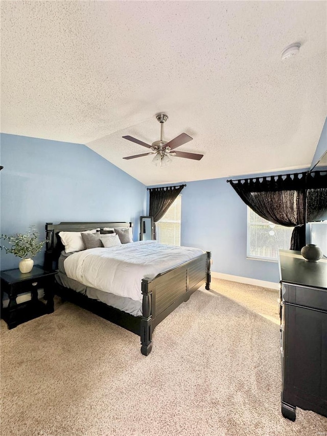 carpeted bedroom featuring baseboards, a textured ceiling, ceiling fan, and vaulted ceiling