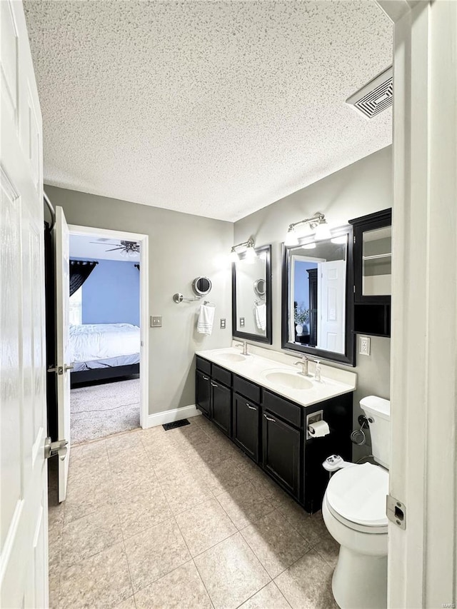 ensuite bathroom with double vanity, visible vents, toilet, and a sink