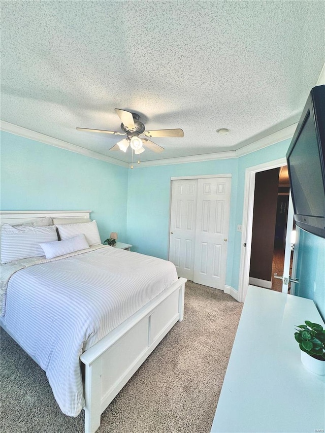 bedroom featuring a ceiling fan, a closet, a textured ceiling, crown molding, and light colored carpet