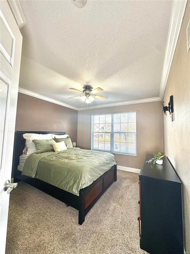 bedroom with carpet floors, a textured ceiling, a ceiling fan, and ornamental molding