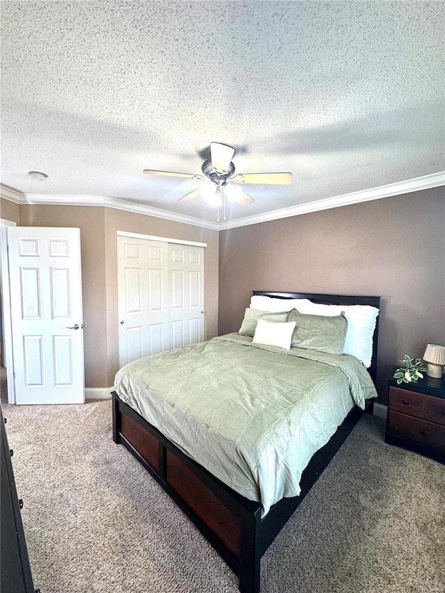 bedroom with a ceiling fan, a closet, a textured ceiling, crown molding, and carpet flooring