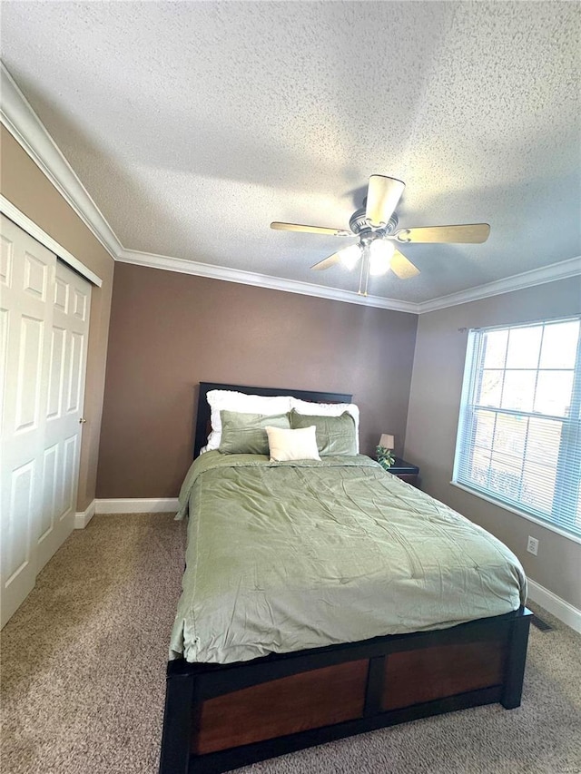 bedroom featuring baseboards, carpet floors, a ceiling fan, and crown molding