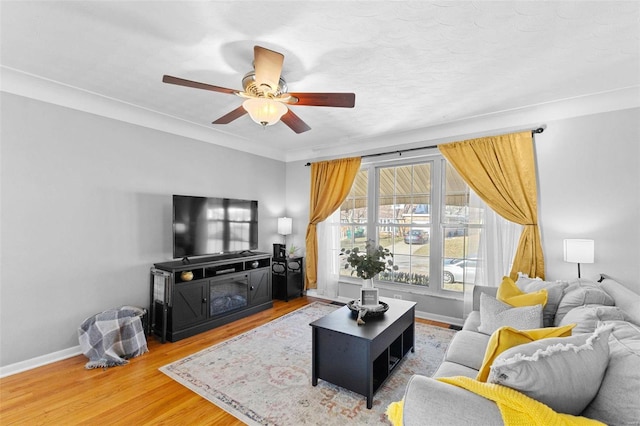 living area with ceiling fan, baseboards, and wood finished floors