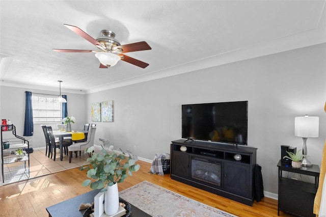 living area with ceiling fan, baseboards, and wood finished floors