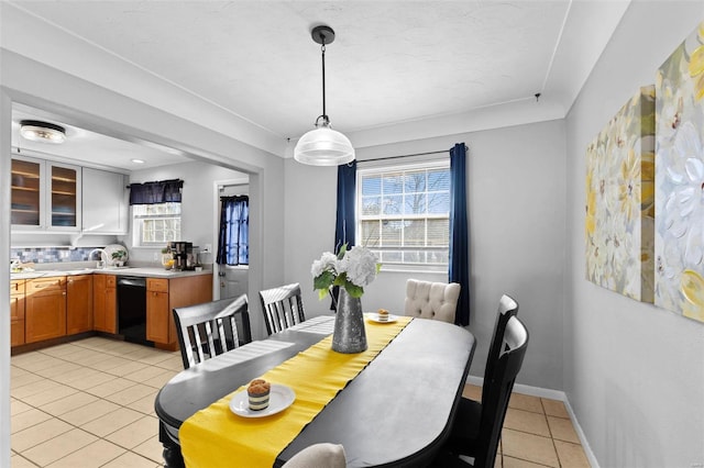 dining room featuring light tile patterned floors, baseboards, and a healthy amount of sunlight