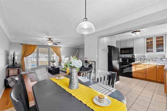 dining space with light tile patterned floors, crown molding, and a ceiling fan