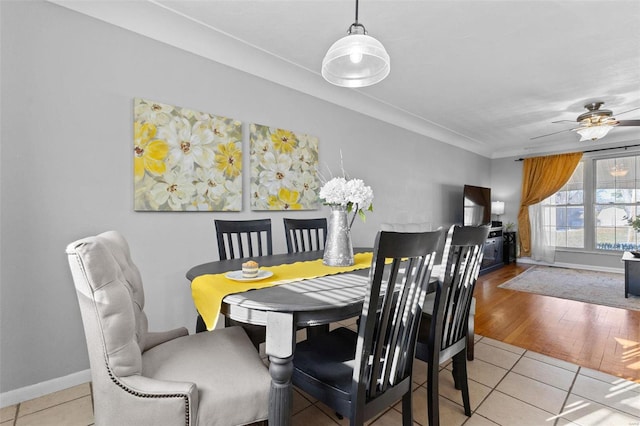 dining space with tile patterned flooring, crown molding, baseboards, and ceiling fan