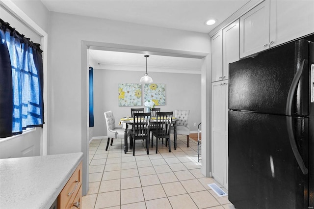 dining area with light tile patterned floors, visible vents, crown molding, and baseboards