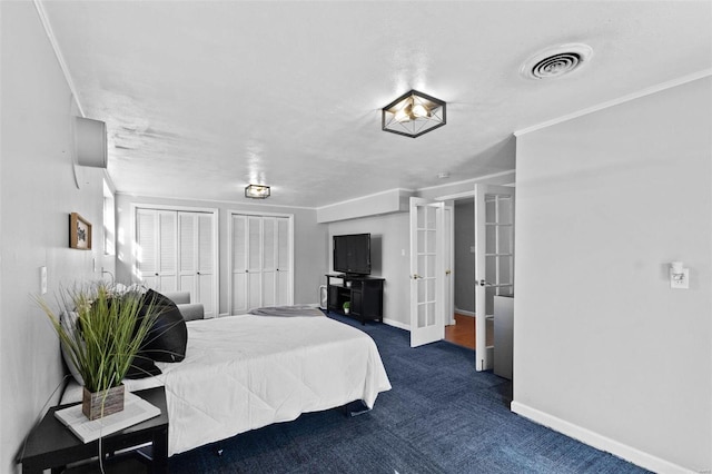 carpeted bedroom featuring visible vents, crown molding, baseboards, multiple closets, and french doors