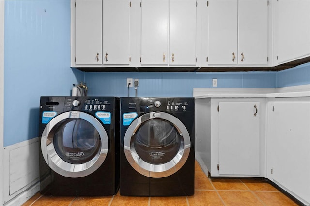 laundry area featuring washer and dryer, cabinet space, and light tile patterned floors