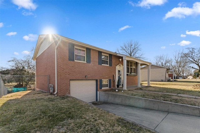 bi-level home featuring brick siding, an attached garage, a front lawn, fence, and driveway