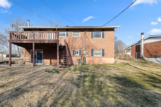 back of property with fence, a wooden deck, a yard, stairs, and brick siding